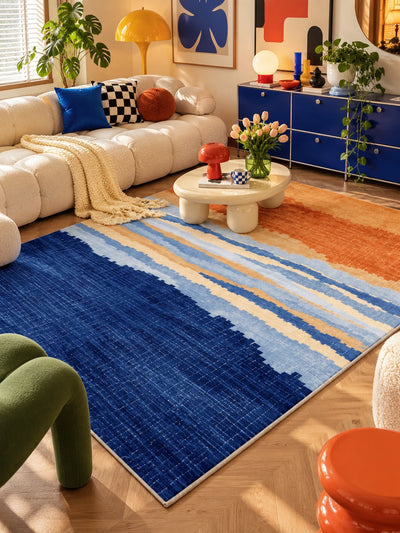 Sunset gradient stripe rug under a cream coffee table, with boucle sofa and royal blue sideboard