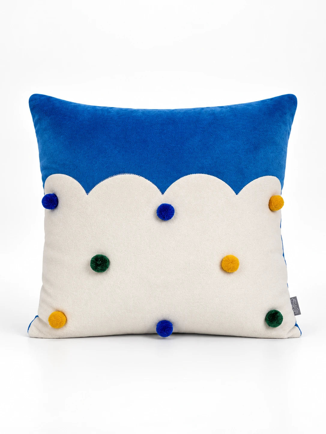 
Cobalt and cream throw pillow with a scalloped cloud edge and blue, green and yellow pompom dots, studio shot