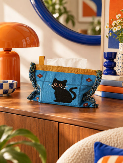 blue cat knitted tissue pouch on a dresser with tissues feeding from the slot