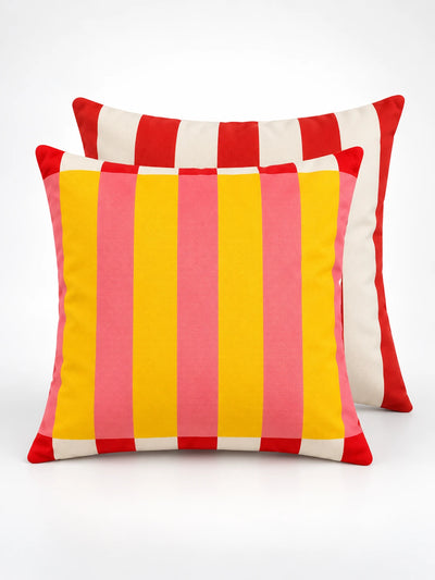 Striped throw pillow in yellow and pink with red trim, red striped pillow behind