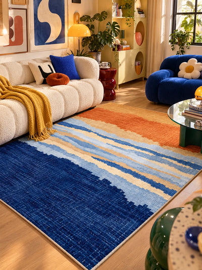 Gradient stripe rug between a cream boucle sofa and cobalt loveseat, mustard throw draped