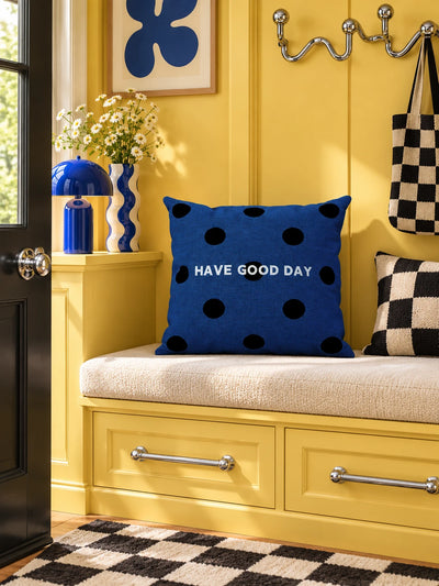 navy polka dot pillow on a yellow entryway bench with checkered accents