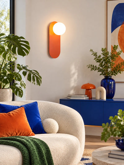 Warm-lit minimalist wall lamp in a styled bedside corner