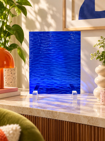 cobalt rippled glass sheet on a marble-top dresser with a terrazzo lamp