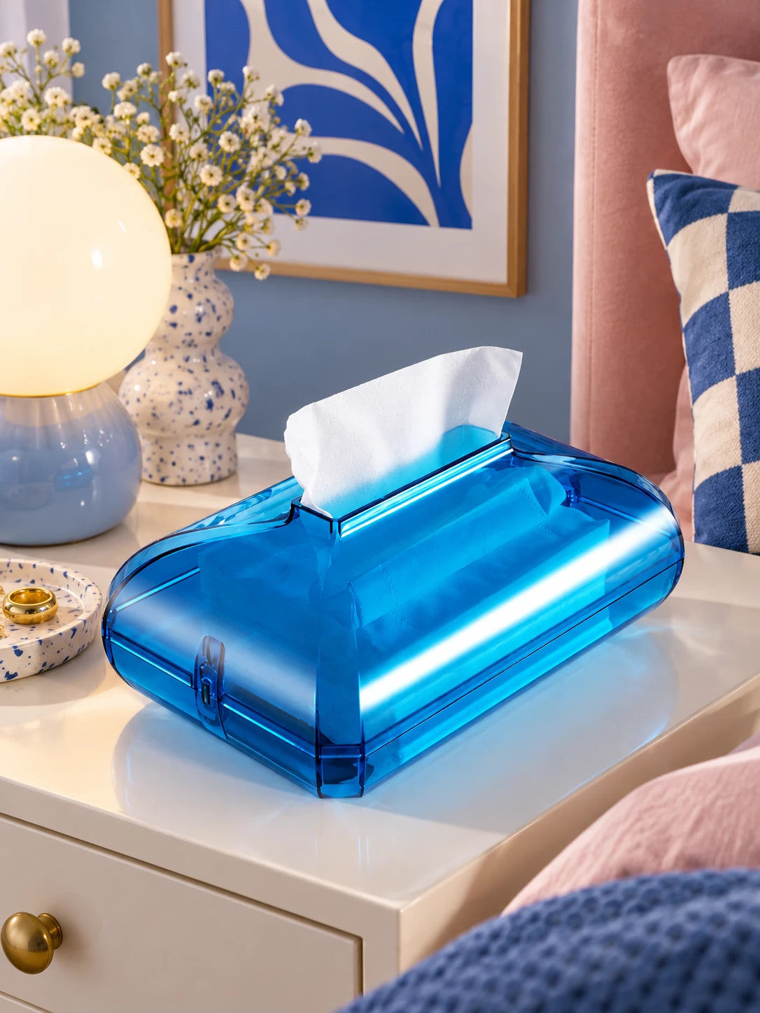 Blue acrylic tissue box glowing on a bedside table in a blue and pink bedroom