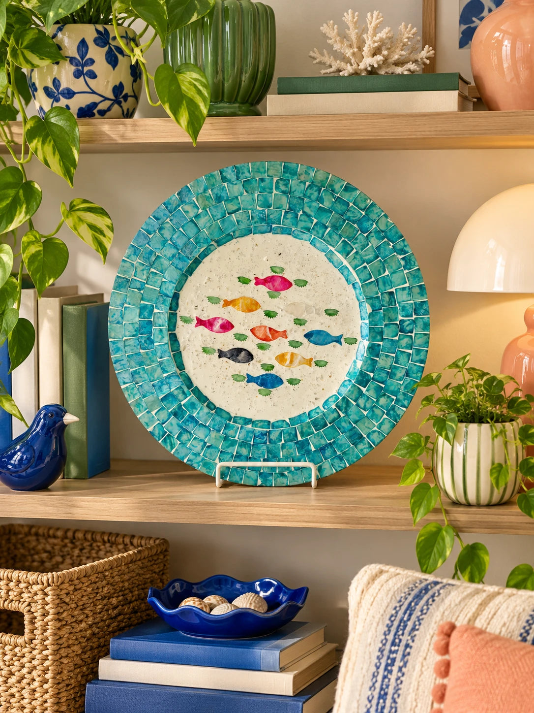 Turquoise shell tray on a wooden shelf with coral, a blue bird figure and baskets