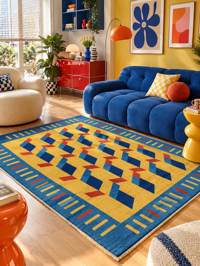 Blue ribbon pattern rug anchoring a royal blue sofa with checkered pillow and yellow stool