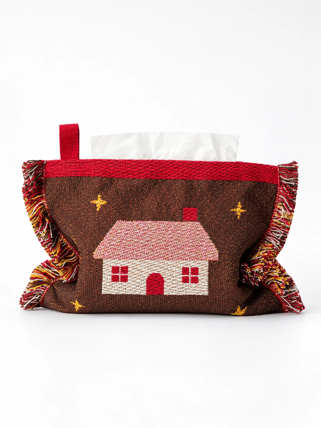 
brown knitted tissue holder with cottage cabin design, red trim and tassels, studio view