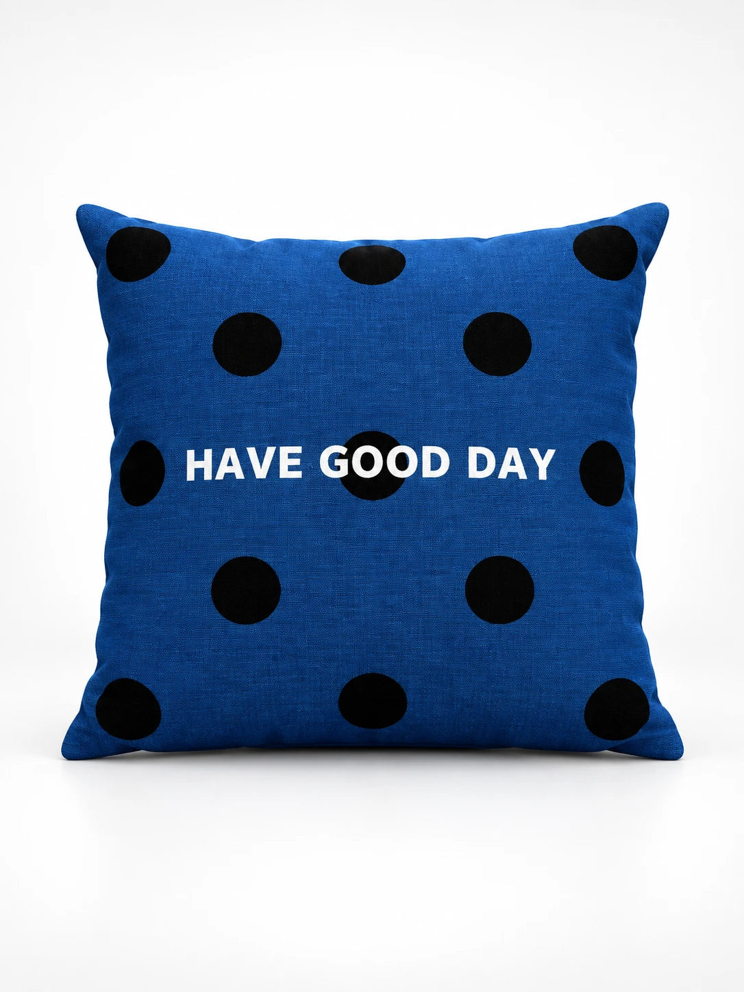 
navy blue throw pillow with black polka dots and white HAVE GOOD DAY lettering, studio view