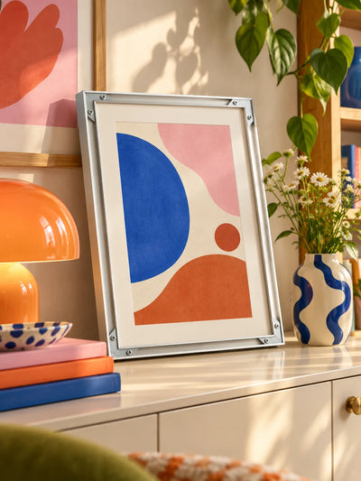 silver aluminum frame with print standing on a shelf ledge