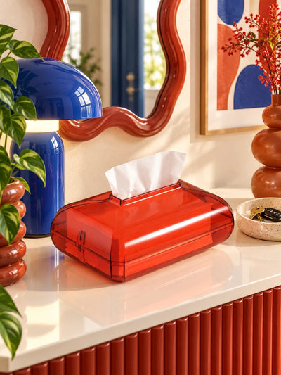 Red acrylic tissue box on a console with a blue mushroom lamp and red wavy mirror
