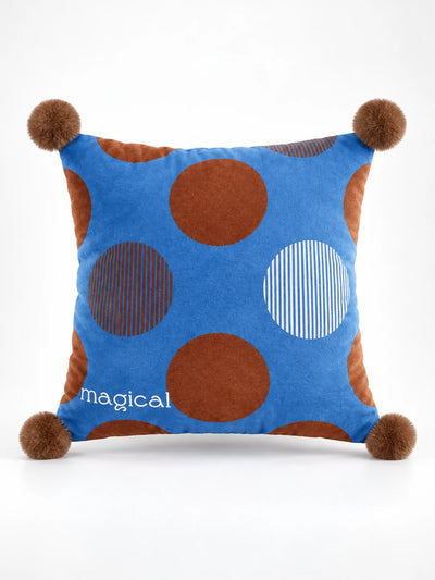 Cobalt throw pillow with big brown polka dots, two pinstriped dots and brown pompom corners
