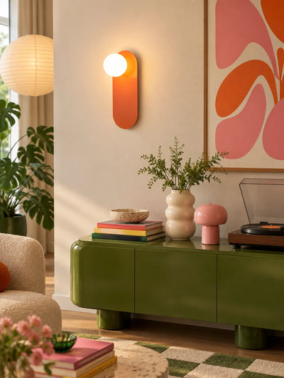 Minimalist wall lamp above a green sideboard with a record player