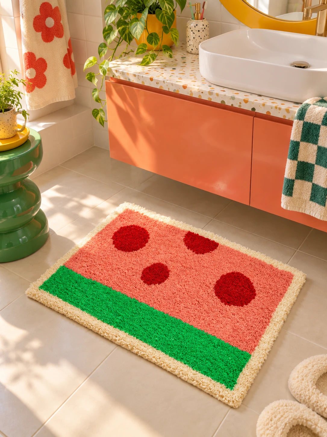 watermelon bath mat on tile in front of an orange floating vanity and white sink