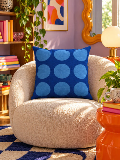 blue dot-grid pillow on a cream boucle armchair