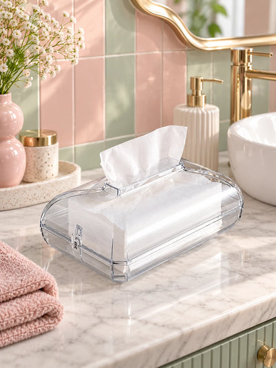 Clear acrylic tissue box on a marble bathroom counter with pink and gold accents