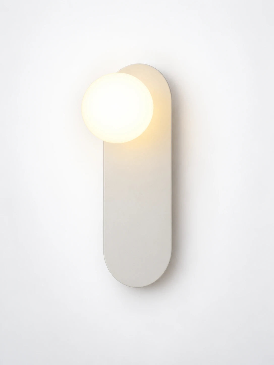 
White minimalist wall lamp with soft round shade, studio shot