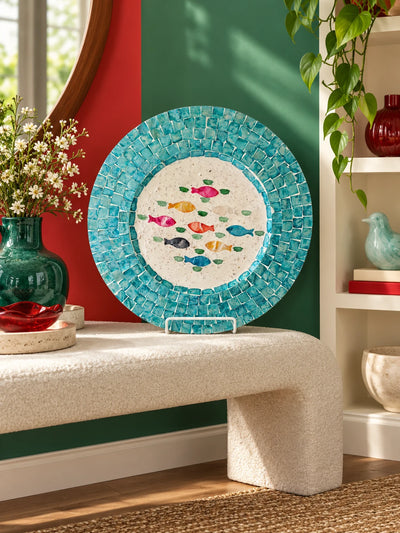 Fish mosaic display plate on a boucle bench against red and green walls